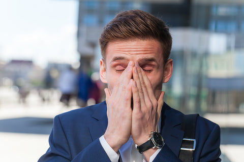 Man holds hands over face like he's about to sneeze